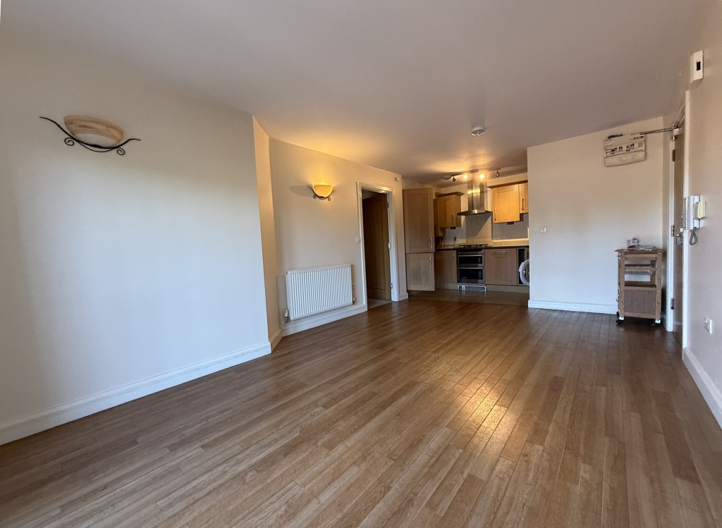 Lot: 187 - GROUND FLOOR APARTMENT IN GATED COMPLEX - Living room area looking to the kitchen